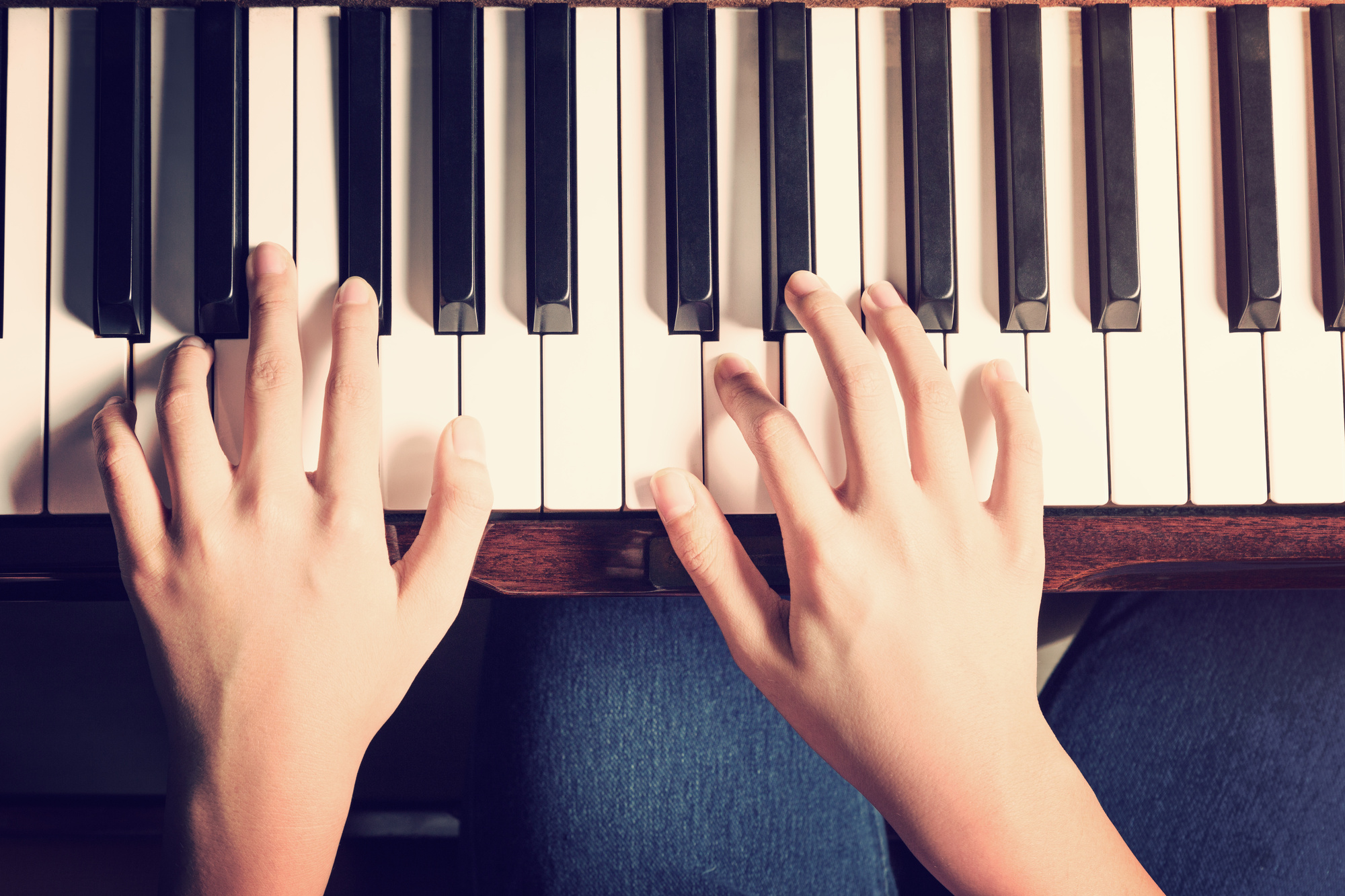 Female hands playing piano with vintage look